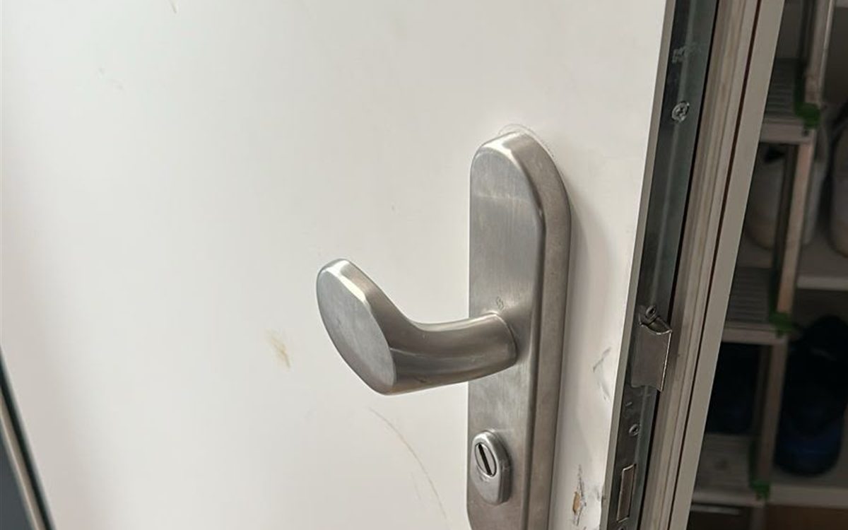 Geöffnete weiße Wohnungstür mit Schutzbeschlag